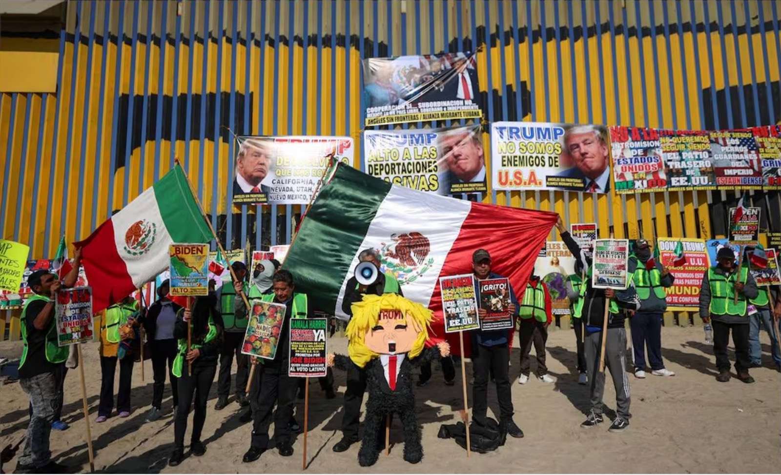 “Baby Trump, te comportas como niño”; migrantes y deportados castigan piñata de Donald frente al muro fronterizo